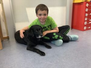 Schüler sitzt neben einem Hund